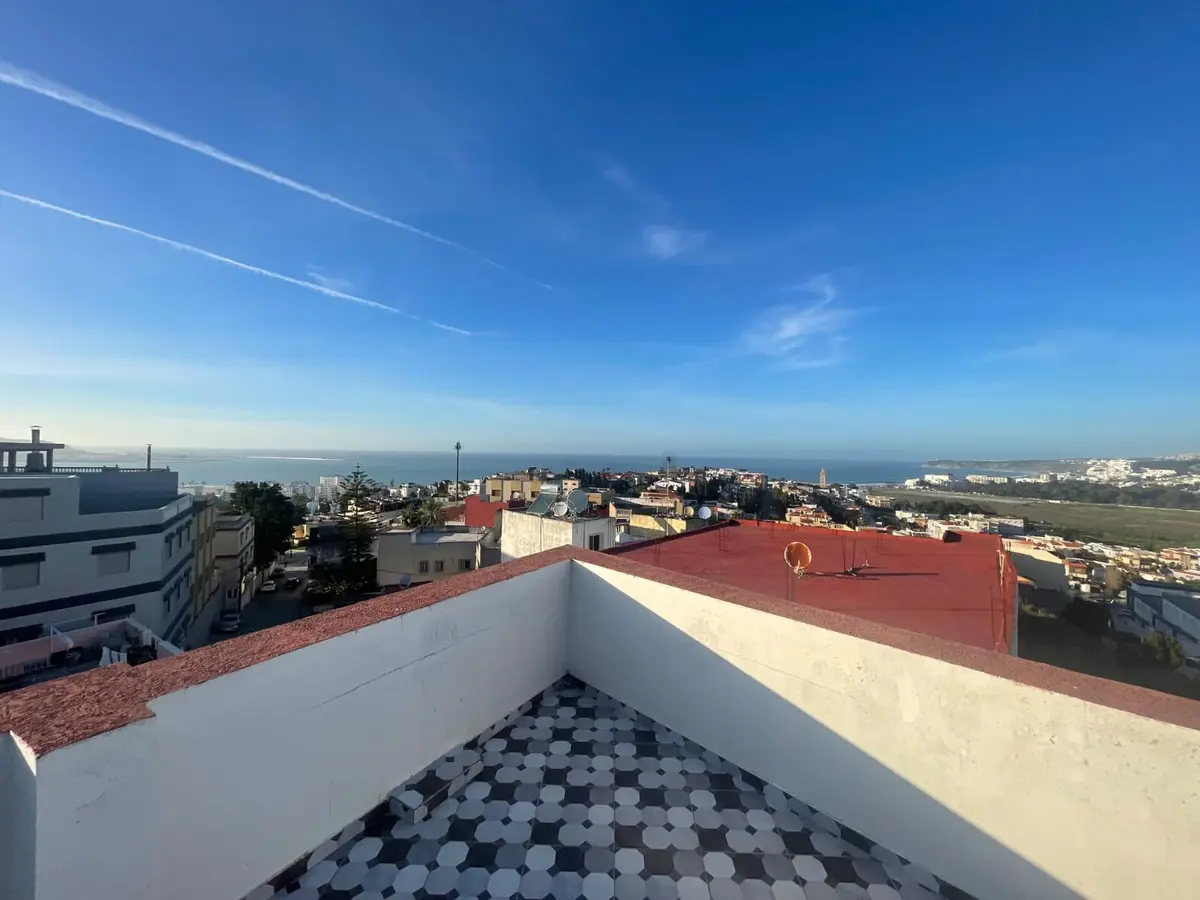 Shared rooftop terrace view across Tangier toward the sea