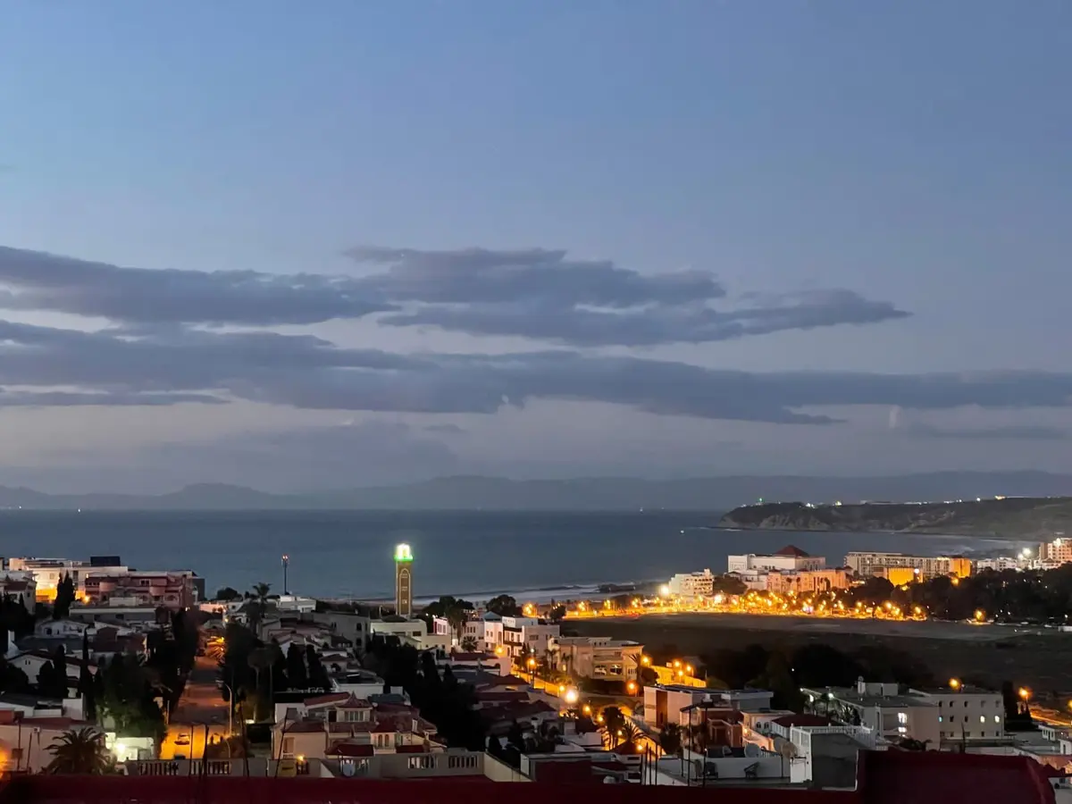 Tangier and the sea illuminated at dusk from the shared rooftop