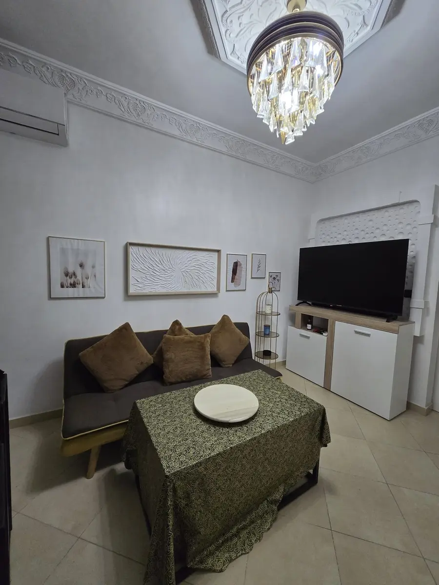 Living room with seating, coffee table, television, and decorative Moroccan plasterwork