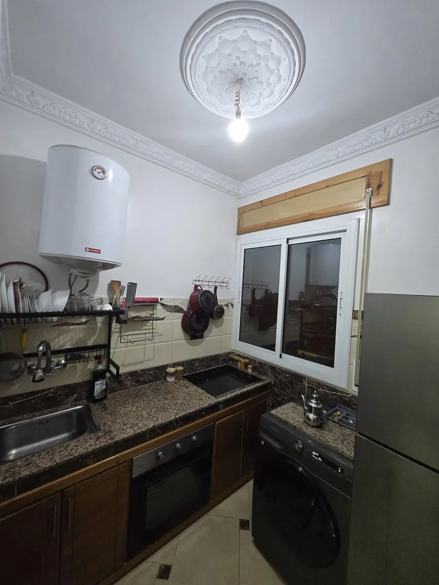 Kitchen with full-size refrigerator, oven, hob, and storage