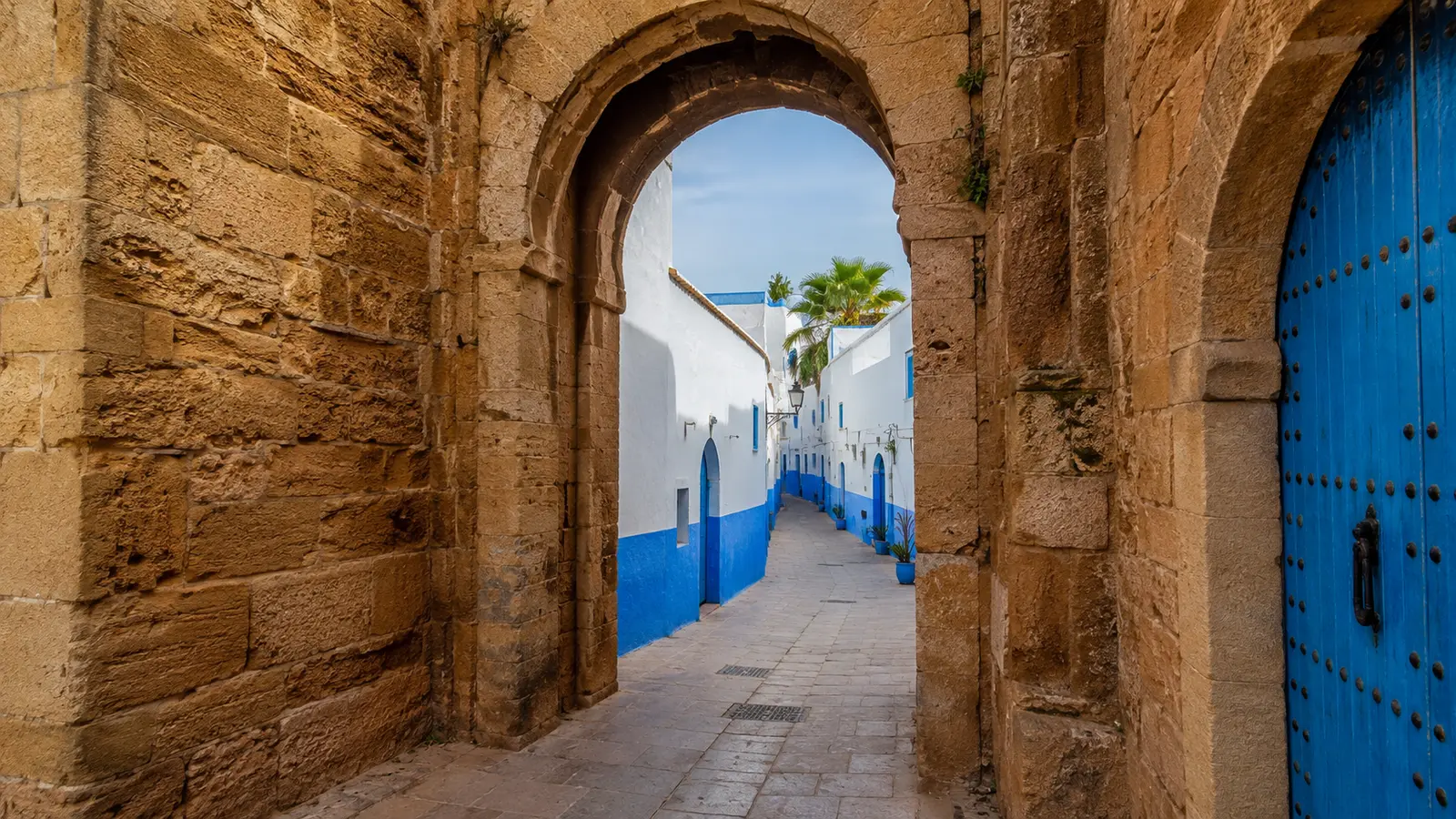 Stone gateway and blue-white lane at the Kasbah of the Udayas in Rabat