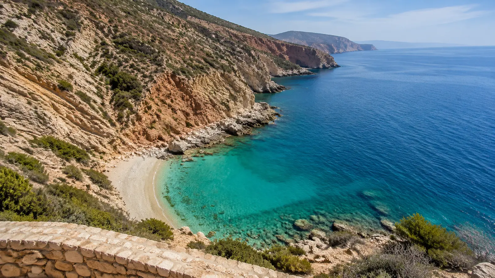 Rif cliffs descending to a turquoise Mediterranean cove near Al Hoceima